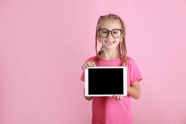 Elinde tabletle pembe arka planda gülümseyen komik kız çocuğu. Gözlüklü beyaz çocuk boş ekran gösteriyor ve kameraya bakıyor. Reklamlar boş. Gözbebeği ürünü tanıtıyor
