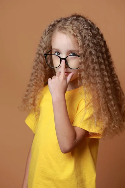 Sarı Tişörtlü Sevimli Kıvırcık Kız Turuncu Arka Planda Izole Edilmiş — Stok fotoğraf