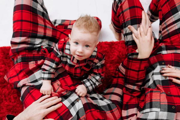 Happy Young Parents Baby Boy Same Pyjamas Lying Red Floor — Zdjęcie stockowe