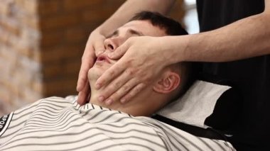 Kozmetik uzmanı berber dükkanında yüzüne krem sürerek masaj yapıyor. traş sürecinden sonra.