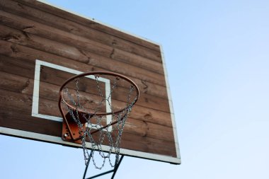 Basketbol potası, metal ağ ve mavi gökyüzü arka planında oyun için tahta sedye. Basketbol sahası açık havada. Sokak arasında eğlence amaçlı spor ekipmanları, sokak arasında oyun alanı.