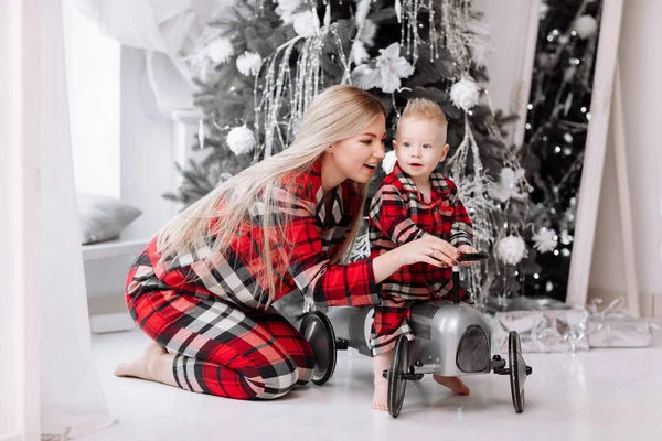 Young Mom Cute Baby Son Red Checked Pyjamas Plays Toy — Stockfoto