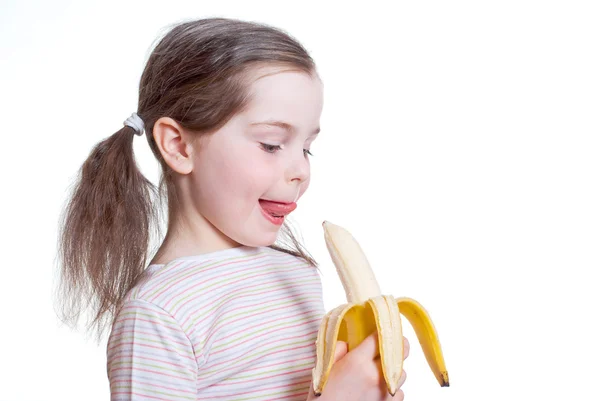 La bambina felice ha morso la banana Immagine Stock