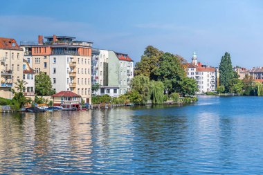 Berlin, Almanya - 6 Eylül 2021: Dahme Nehri 'nin sol kıyısında evleri ve Gutenbergstrasse caddesinde tatil evleri ve bir tekne iniş sahnesi olan 