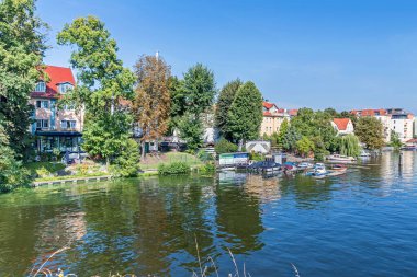 Berlin, Almanya - 6 Eylül 2021: Dahme Nehri 'nin sol kıyısı, batıda ve kuzeybatıda yeni bölgeler ve bir tekne iniş sahnesi ile