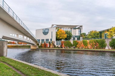 Berlin, Almanya - 18 Ekim 2021: Almanya Federal Başkonsolosluğu 'nun (Bundeskanzleramt) arka kısmına sahip River Spree Köprüsü, renkli duvar ve bir rektör parkı