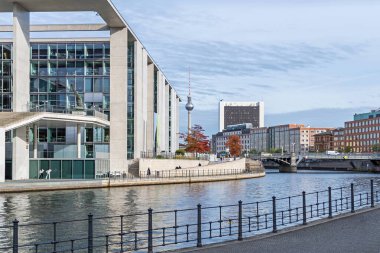 Berlin, Almanya - 18 Ekim 2021: Spree nehri kıyısında Schiffbauerdamm adında Marie-Elisabeth-Lueders Evi solda, televizyon kulesi ve köprü Marschallbruecke