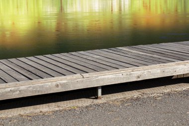 Tahta tezgah ya da kıyıdaki masa, diğer kıyıdaki suya yansıyor..