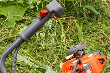 Yeşil çim biçme makinesi, kontrol kolu ve benzin motoru.