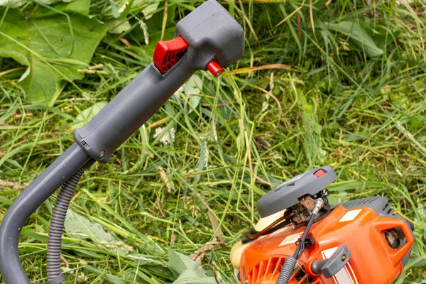 Yeşil çim biçme makinesi, kontrol kolu ve benzin motoru.