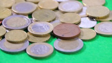 Yeşil kumaştaki madeni paralar döner döner, yakın plan, mali gelir veya yatırım konsepti