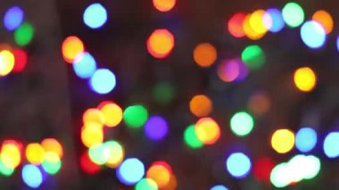 Neşeli bir Noel çelenginin bulanık ışıkları karanlık bir arka planda parıldıyor, yakın plan, Noel 'in ya da tatil havasının deseni