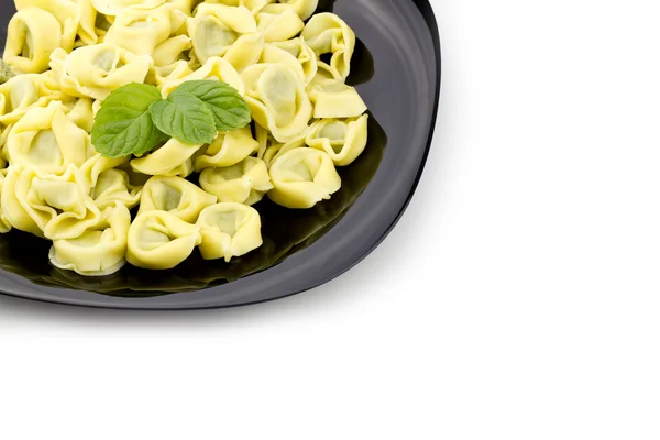 Tortellini on black plate — Stock Photo, Image