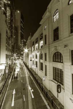 Hong Kong 'un merkez bölgesinin eski caddesinde gece trafik vardı.