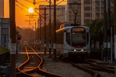 Hong Kong, Çin - 29 Aralık 2021: Tin Shui Wai 'de hafif demiryolu geçişi. LRT, Hong Kong 'da Tuen Mun, Yuen Long ve Tin Shui Wai şirketleri tarafından işletilen hafif demiryolu sistemidir.