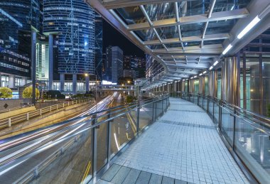Hong Kong şehir merkezindeki modern yaya geçidinin gece manzarası. 
