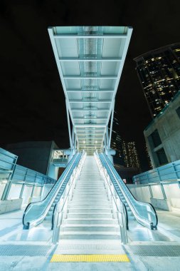 Hong Kong şehir merkezindeki modern yürüyen merdivenin gece manzarası.
