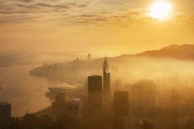 Hong Kong 'un şehir merkezindeki gökdelende, gün doğumunda sisli bir havada.