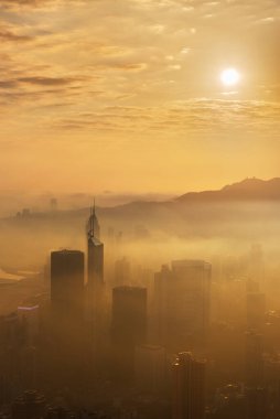 Hong Kong 'un şehir merkezindeki gökdelende, gün doğumunda sisli bir havada.