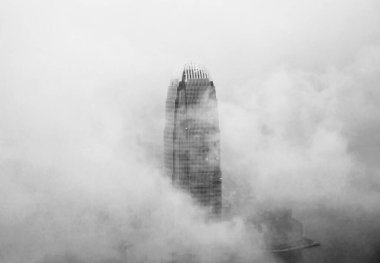 Hong Kong şehrinin merkezinde sisli bir gökdelen.