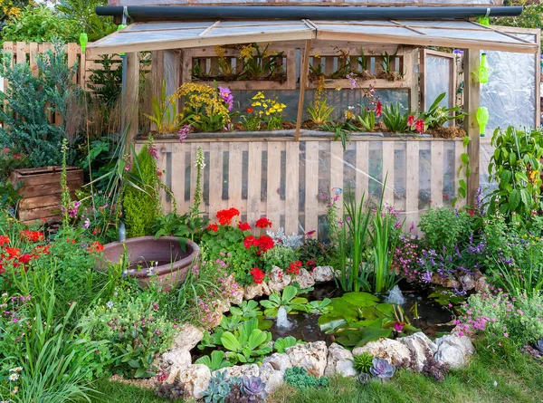 Small green house in backyard flower garden