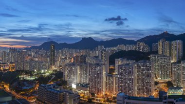 Hong Kong şehrinin manzarası gökyüzü ve Lion Rock tepesi alacakaranlıkta.