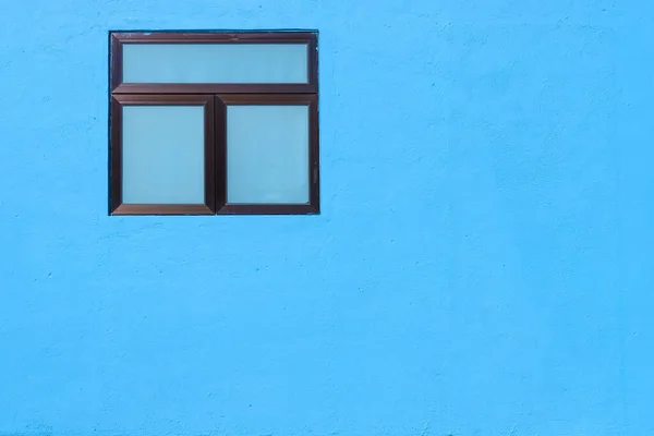 Window on wall of a blue color house