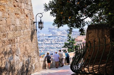 Monaco 'da. Monte Carlo Limanı. Rampe de la Major merdiveninin manzarası. Turistler limandaki yatlara bakıyorlar.. 