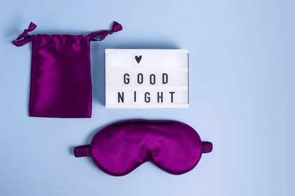 紫の睡眠マスクと明るい夜の願いを青の背景にライトボックス — ストック写真