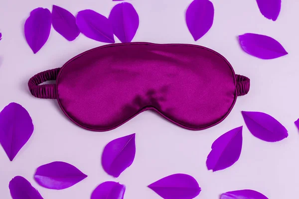 装飾的な羽を持つ薄紫の背景にフレーム内の紫色の睡眠マスク — ストック写真