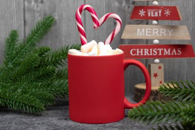 İçinde şekerlemeler ve baston şekerlerden yapılmış bir kalp olan yazıtlar için kırmızı kupa. İçinde lokum ve sıcak çikolata olan Noel kartı..