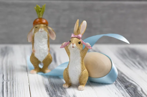 Dva Velikonoční Zajíčci Dřevěným Vejcem Modrým Obvazem Bílém Dřevěném Pozadí — Stock fotografie