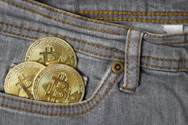 Gri kadın pantolonu cebinde 3 altın bitcoin..