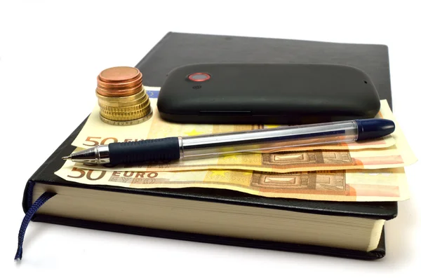 Caderno, móvel, caneta, moedas e notas — Fotografia de Stock