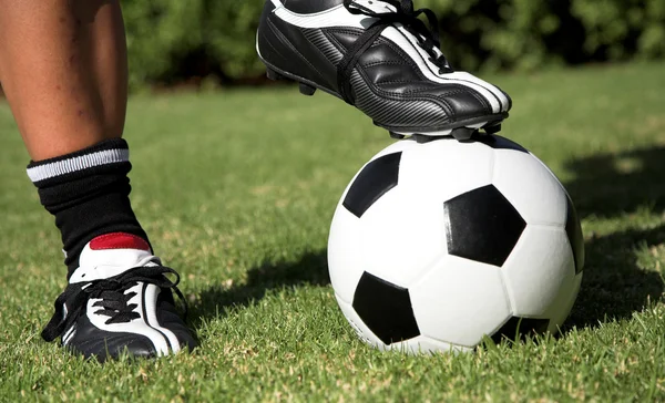 Soccerboot on top of soccer ball Stock Picture