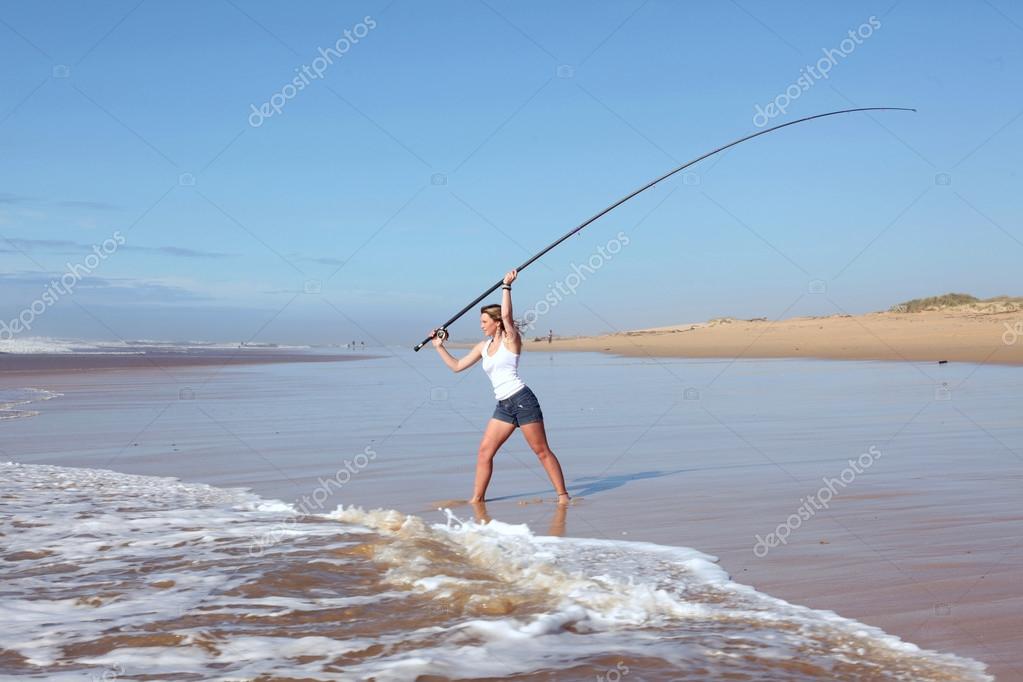 Beach lady casting fishing rod — Stock Photo © jacojvr 25754037
