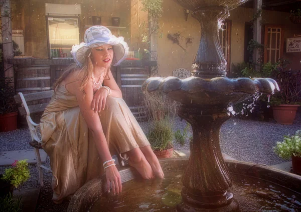 Blonde lady with feet in water fountain — Stock Photo, Image