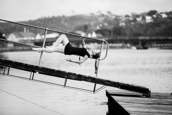 Ballerina lying on the bridge railing — Stock Photo, Image