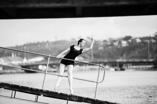 Ballerina leaning through a bridge railing — Stock Photo, Image