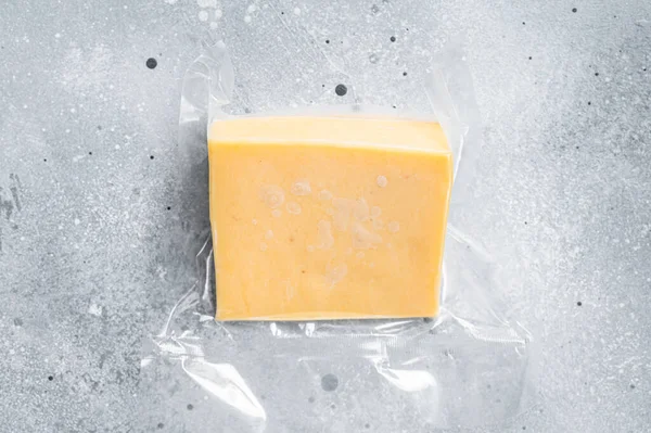 Organic Sharp Cheddar Cheese w opakowaniu próżniowym. Szare tło. Widok z góry — Zdjęcie stockowe