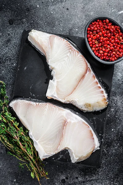 Tahtada çiğ köpekbalığı bifteği. Siyah arka plan. Üst görünüm