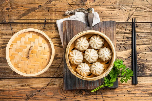 Momo dumplings in a bamboo steamer. Wooden background. Top view — Stock Photo, Image