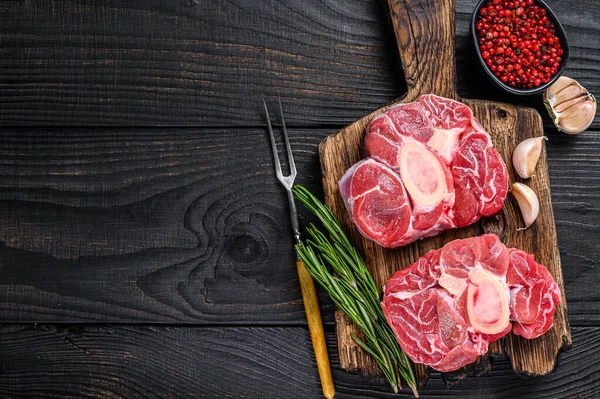 Çiğ et osso buco dana biftek, İtalyan ossobuco 'su. Kara tahta arka plan. Üst Manzara. Boşluğu kopyala