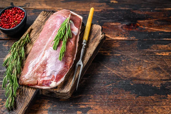 Çiğ ördek eti, göğüs bifteği, şifalı ve biberiyeli. Koyu ahşap arka plan. Üst Manzara. Boşluğu kopyala — Stok fotoğraf