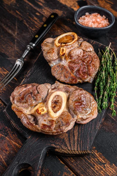 Osso Buco bifteği, İtalyan ossobuco bifteği. Koyu ahşap arka plan. Üst görünüm