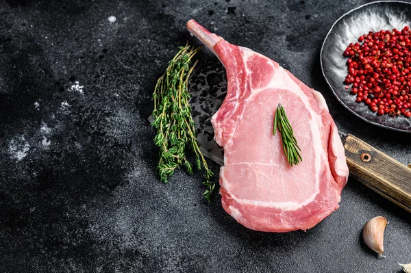 Et satırında çiğ balta domuz pirzolası biftek. Siyah arka plan. Üst Manzara. Boşluğu kopyala — Stok fotoğraf