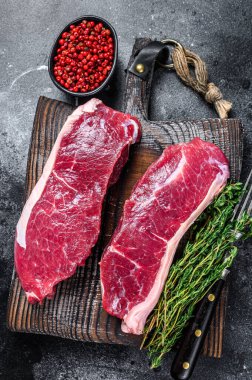 Çiğ mermer sığır eti bifteği. Siyah arka plan. Üst görünüm