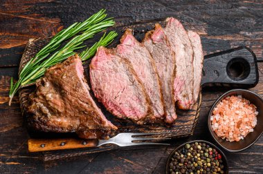 Dilimlenmiş sığır eti fileto üçlü biftek bbq. Koyu ahşap arka plan. Üst görünüm