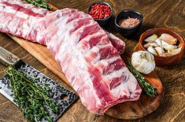 Taze çiğ kuzu pirzolası. Kesme tahtasına baharat dökülmüş. Ahşap arka plan. Üst görünüm