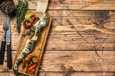 Buzlu ve sebzeli ızgara balık. Ahşap arka plan. Üst Manzara. Boşluğu kopyala